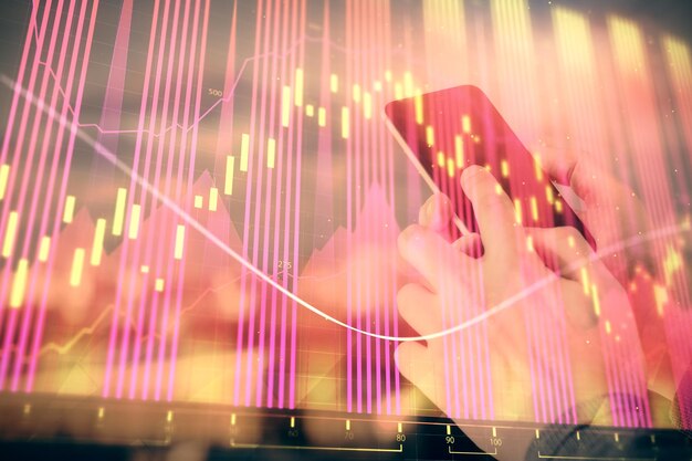 Doppelbelichtung der Hände eines Mannes, der ein digitales Gerät hält und verwendet, und einer Forex-Grafik, die ein Finanzmarktkonzept zeichnet