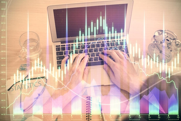 Doppelbelichtung der Hände eines Mannes, der über die Laptop-Tastatur tippt, und Devisendiagramm-Hologramm-Zeichnung, Draufsicht, Finanzmarktkonzept