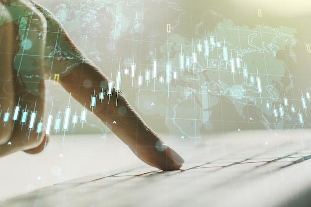 Doppelbelichtung des abstrakten kreativen Finanzdiagramms mit Weltkarte und mit Händen, die auf der Computertastatur auf dem Bank- und Buchhaltungskonzept im Hintergrund tippen