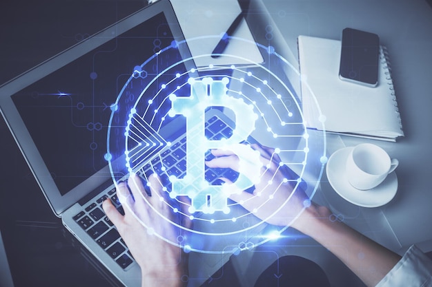 Doppelbelichtung von Frauenhänden, die am Computer tippen, und Hologramm zum Thema Kryptomarkt, das Blockchain-Konzept zeichnet