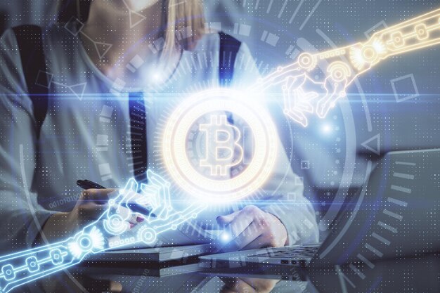 Doppelbelichtung von Frauenhänden, die am Computer tippen, und Hologramm zum Thema Kryptomarkt, das Blockchain-Konzept zeichnet