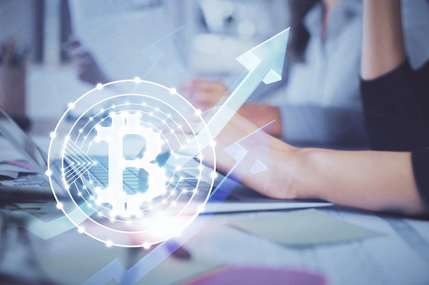 Doppelbelichtung von Frauenhänden, die am Computer tippen, und Hologramm zum Thema Kryptomarkt, das Blockchain-Konzept zeichnet