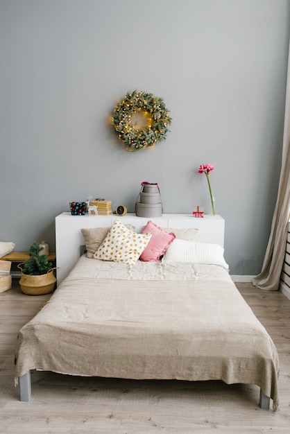 Doppelbett mit hellen Kissen und dekoriertem Schlafzimmer