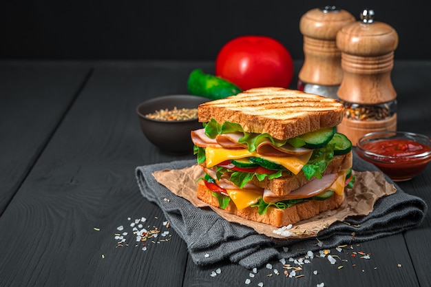 Doppelsandwich mit gegrilltem Toastschinkengemüse und Käse auf dunklem Hintergrund mit Kopierraum