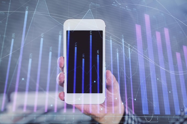 Doppelte Exposition der Hände des Menschen beim Halten und Verwenden eines digitalen Geräts und Zeichnung von Forex-Grafiken