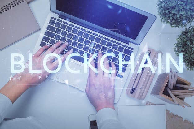 Doppelte Exposition von weiblichen Händen, die an einem Computer arbeiten, und Hologrammzeichnung mit Blockchain-Thema Top View Bitcoin-Kryptowährungskonzept