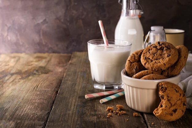 Foto doppelte schokoladenplätzchen mit chips auf einer schüssel und milch im glas