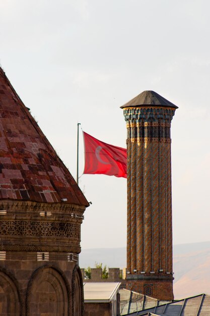 Doppeltes Minarett Madrasa, türkische Flagge im Hintergrund. Erzurum, Türkei