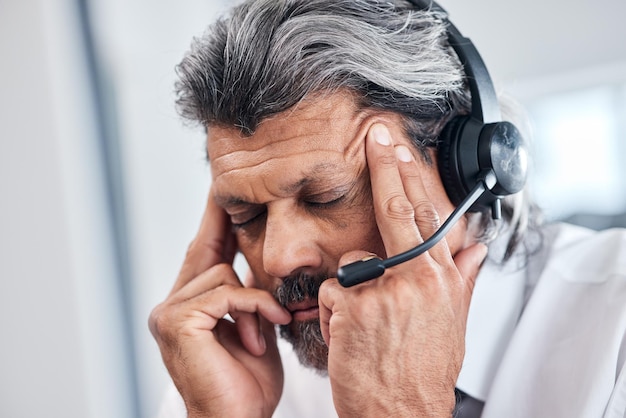 Dor de cabeça call center rosto e homem de negócios com depressão telemarketing erro ou esgotamento e crise serviço ao cliente dor de enxaqueca e pessoa idosa estresse problema de telecomunicações e sobrecarregado