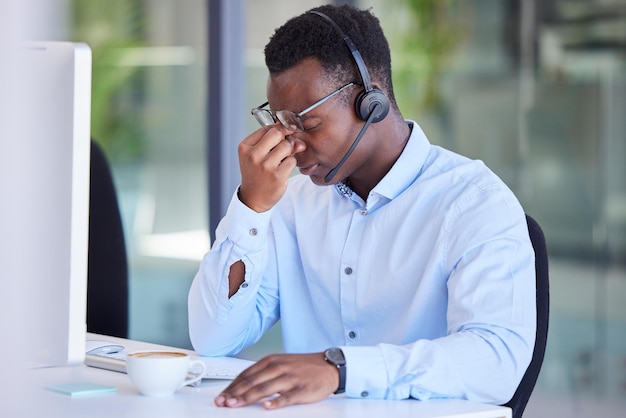 Dor de cabeça cansada e call center com empresário no computador para estresse frustrado e saúde mental Suporte ao cliente por telemarketing e entre em contato conosco com funcionário com ansiedade de esgotamento e excesso de trabalho