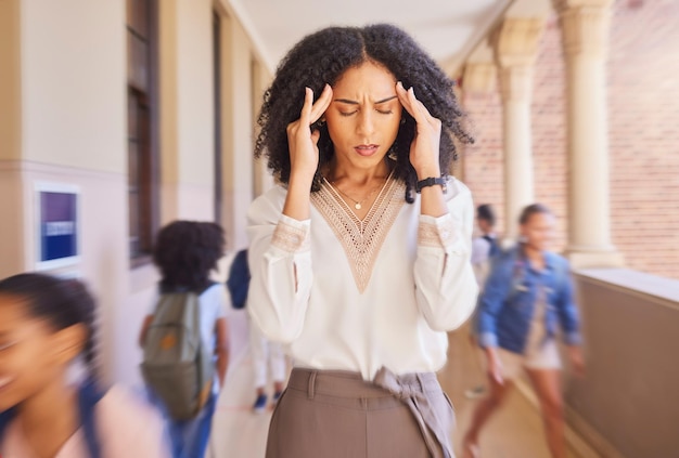 Dor de cabeça cansado e estresse professor na escola com crianças rápidas pensando em estresse no trabalho mentalidade educacional e desafio de gerenciamento no corredor Mulher negra triste com raiva e dor com velocidade ou campus movimentado