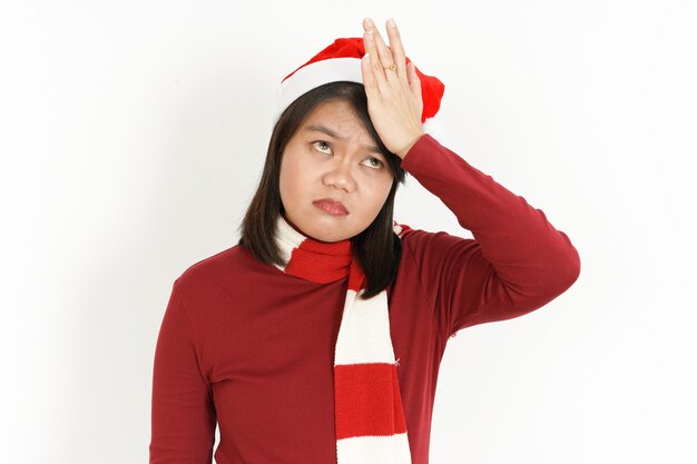 Dor de cabeça de uma linda mulher asiática usando gola alta vermelha e chapéu de Papai Noel isolado no branco