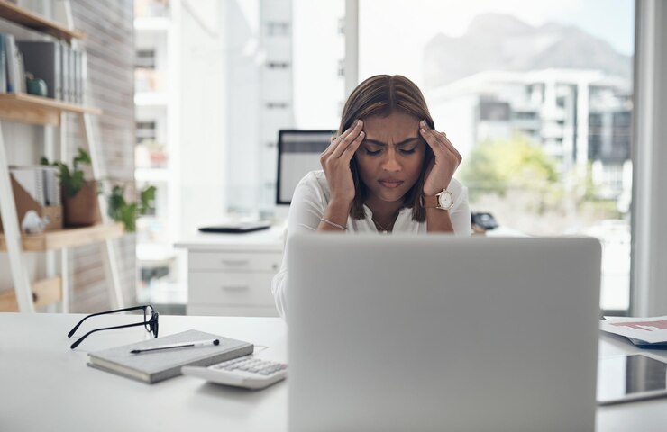 Foto dor de cabeça e mulher de negócios no laptop para problema de orçamento de estresse e risco de saúde mental no escritório fadiga de ansiedade ou pessoa indiana cansada no computador com crise de dívida de enxaqueca ou esgotamento do trabalho