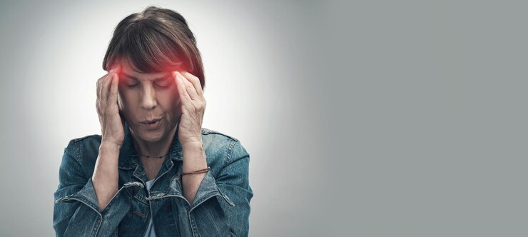 Foto dor de cabeça e mulher ferida com enxaqueca devido a depressão frustrada e ansiedade no espaço de maquete sobreposição vermelha e desconforto por uma mulher se sentindo doente isolada em um fundo cinza de estúdio
