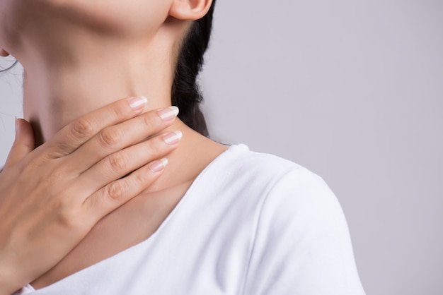 Foto dor de garganta. mão de mulher closeup tocando seu pescoço doente