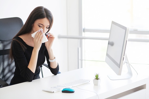 Dor. mulher de negócios doente, sofrendo no trabalho atrás da mesa no escritório dela e tendo problema de alergia.