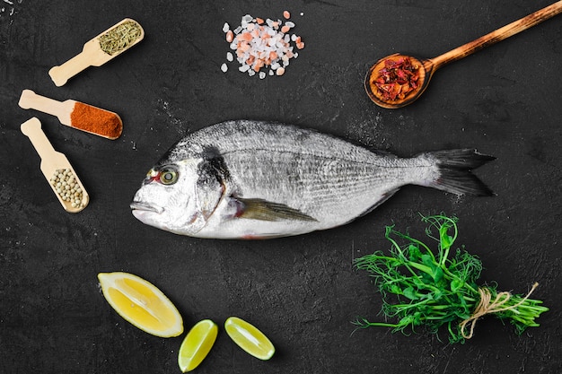 Dorada Fisch auf dem Tisch mit Gewürzen und Kräutern