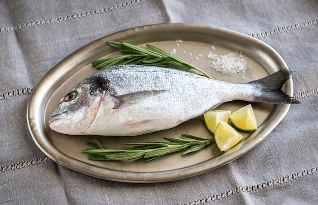 Dorada fresca con ingredientes en la bandeja vintage