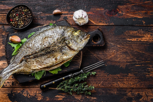 Dorada pescado a la plancha sobre una tabla para cortar