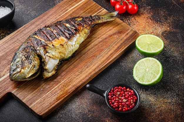 Foto dorada a la plancha o pescado dorado sobre una tabla de cortar con ingredientes