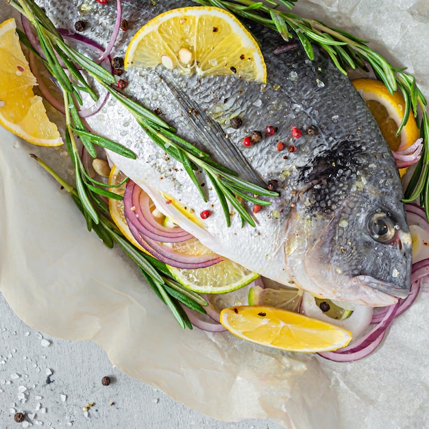 Dorado aus frischem Fisch. Rohes Dorado mit Kräutern, Gewürzen, Zitrone, Limettenscheiben küchenfertig