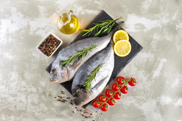 Dorado de peixe fresco de frutos do mar e ingredientes para cozinhar em fundo cinza Vista superior com espaço de cópia