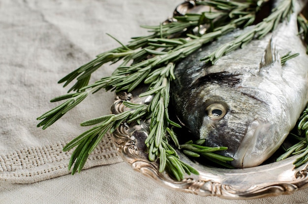 Dorado em uma bandeja de prata Rosemary Closeup Pano de mesa de linho vintage Cozinhando