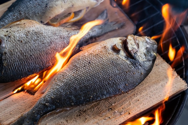 Dorado con limón cocinando a la parrilla con tablón de cedro