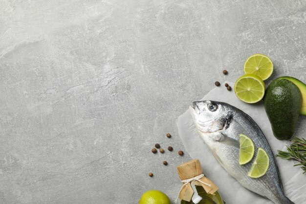 Dorado pescado e ingredientes de cocina sobre fondo gris, vista superior