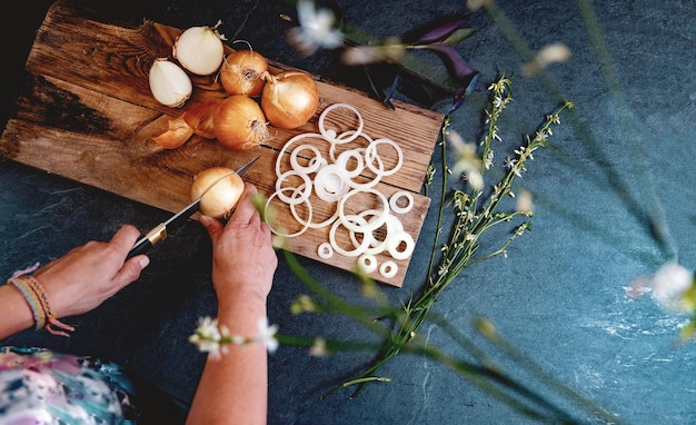 Dore las cebollas y las rebanadas en la tabla de cortar de madera. Fondo de alimentos saludables.