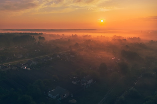 Dorf bei Sonnenaufgang mit Nebel am frühen Morgen