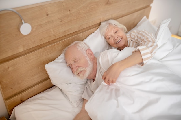 Dormido. Anciano y mujer acostada en la cama juntos