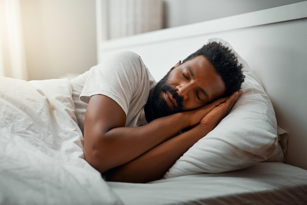 Dormindo no fim de semana Foto recortada de um jovem bonito dormindo na cama em casa