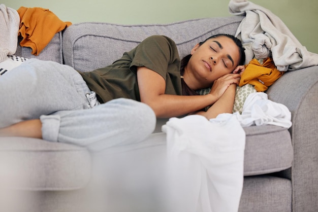 Dormir é muito mais divertido do que essas tarefas Foto de uma jovem dormindo no sofá em casa