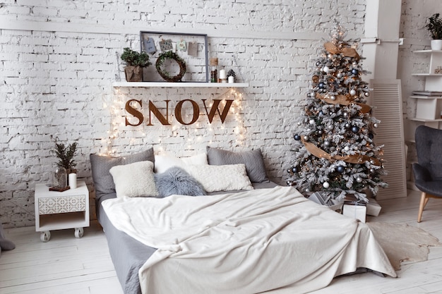 Un dormitorio con un árbol de Navidad decorado y una guirnalda.