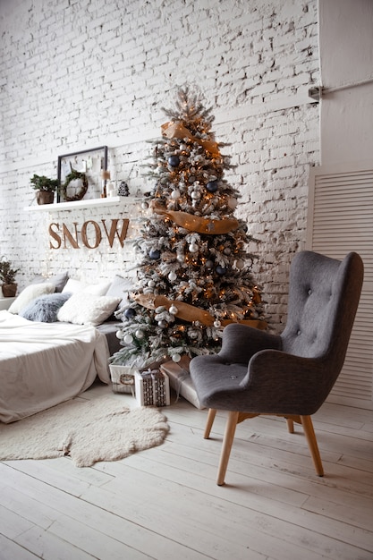 Un dormitorio con un árbol de Navidad decorado y una guirnalda.