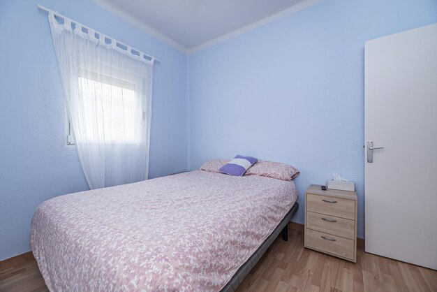 Foto un dormitorio con una cama en un sofá una pequeña mesa y una ventana con cortinas