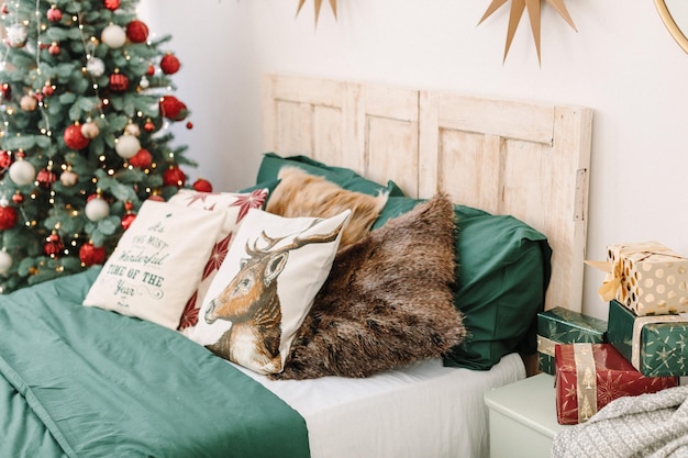 Dormitorio decorado en Navidad en los clásicos colores rojo y verde. Ropa de cama verde, manta navideña roja