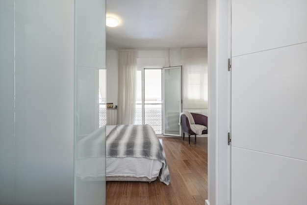 Dormitorio doble en suite con balcón con vistas, baño con ducha independiente y vestidor detrás de un espejo