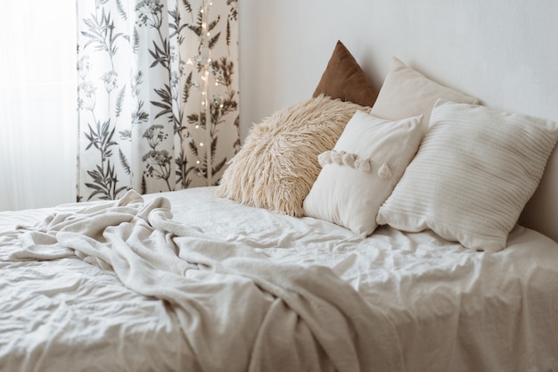 Dormitorio de estilo moderno con almohadas en la cama.