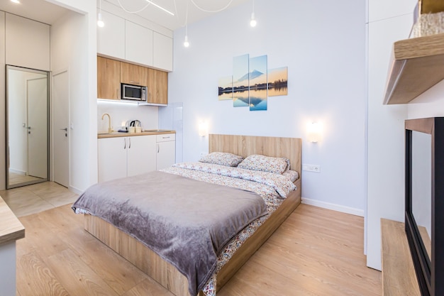 Dormitorio moderno con cama grande y elegante con cocina pequeña