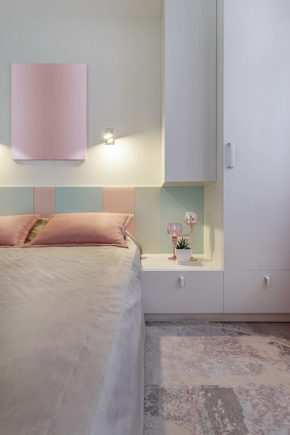 Un dormitorio moderno en colores azul, rosa y blanco con iluminación tenue Foto real