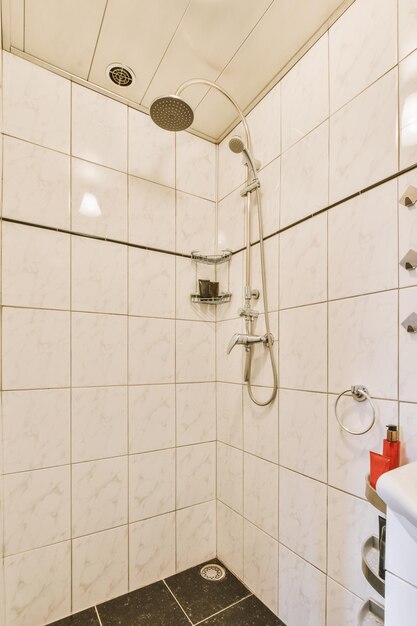 Dormitorio moderno rodeado de azulejos blancos con sistema de ducha en una casa moderna