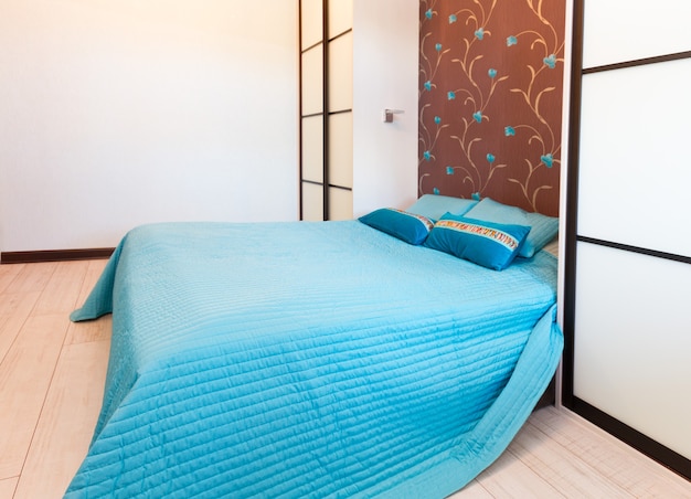 Dormitorio vacío moderno con cama doble y cuna azul