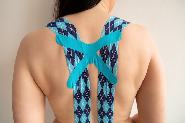 Dorso feminino com fita azul kinesio