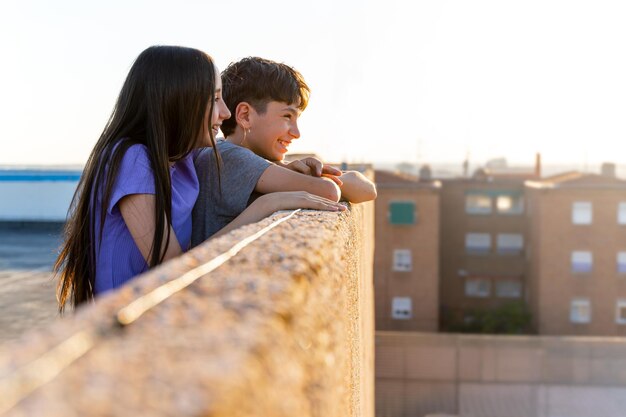 Dos adolescentes caucásicos sonrientes de asomarse a un cenador al atardecer