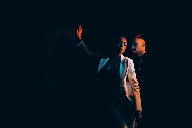 Dos adolescentes dinámicos con atuendo elegante interpretando bailes de moda en un apartamento tipo loft o en un club nocturno