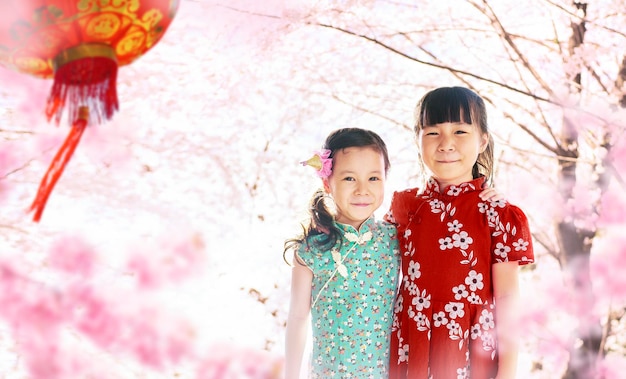 Dos adorables chicas vistiendo cheongsam durante la temporada del año nuevo chino xA