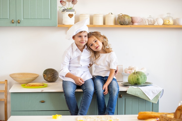 Dos adorables niños en la cocina de casa