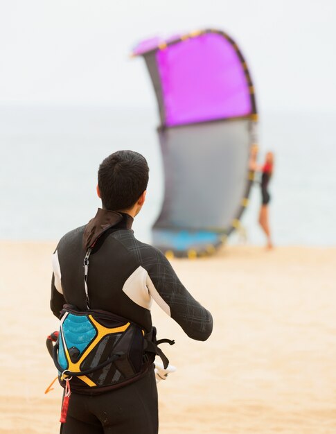 Dos adultos con kiteboardon en la playa